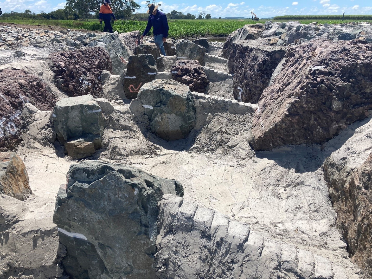 建設中の稚魚育成用魚道の写真では、左側に自然の岩のような地形が、右側に稚魚育成用魚道の階段が写っている。